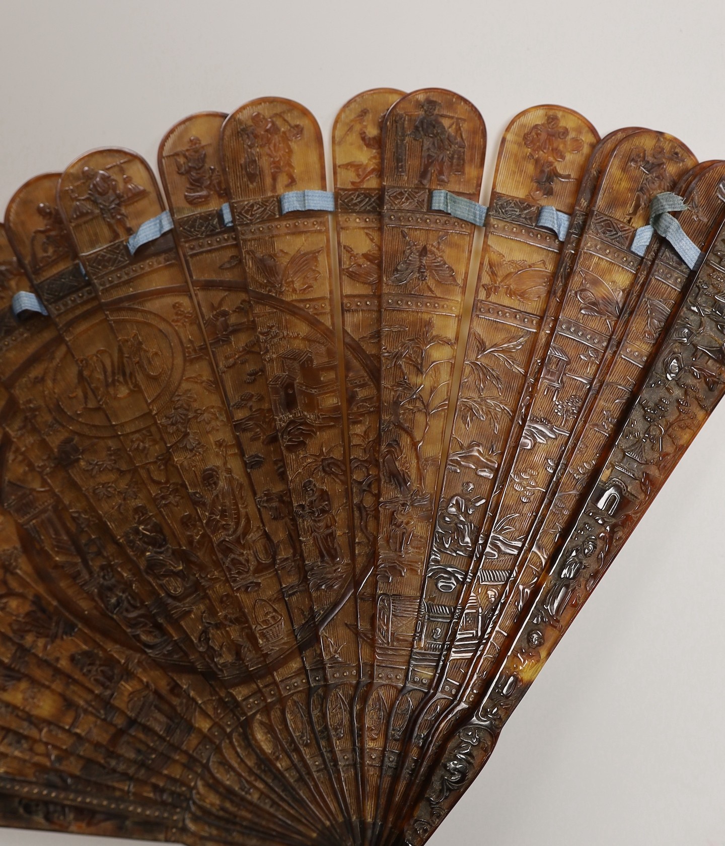 A 19th century Chinese tortoiseshell Brise fan, decorated with a central figural cartouche, 18.5cms high